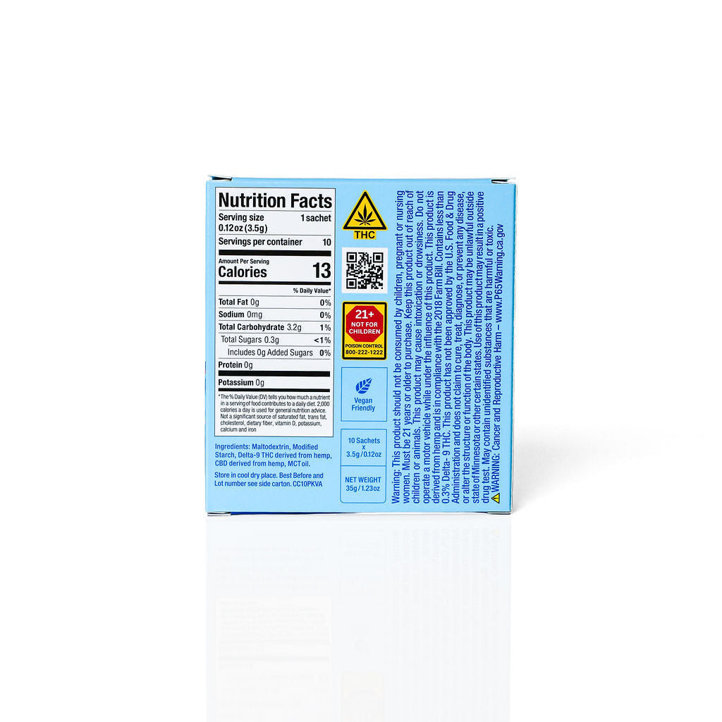 The back of a light blue product box showing nutrition facts, ingredients, and warning labels, photographed on a clean white background with a soft reflection below.