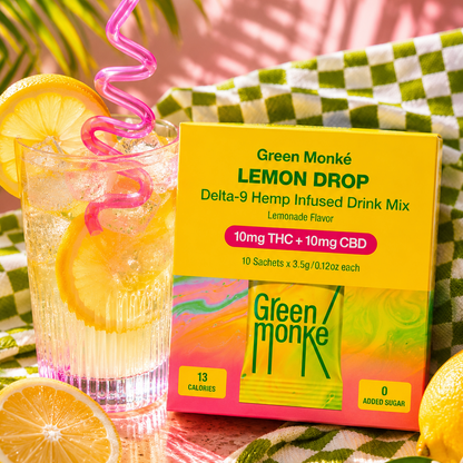 Green Monké Lemon Drop THC drink mix box and glass of clear water with lemon